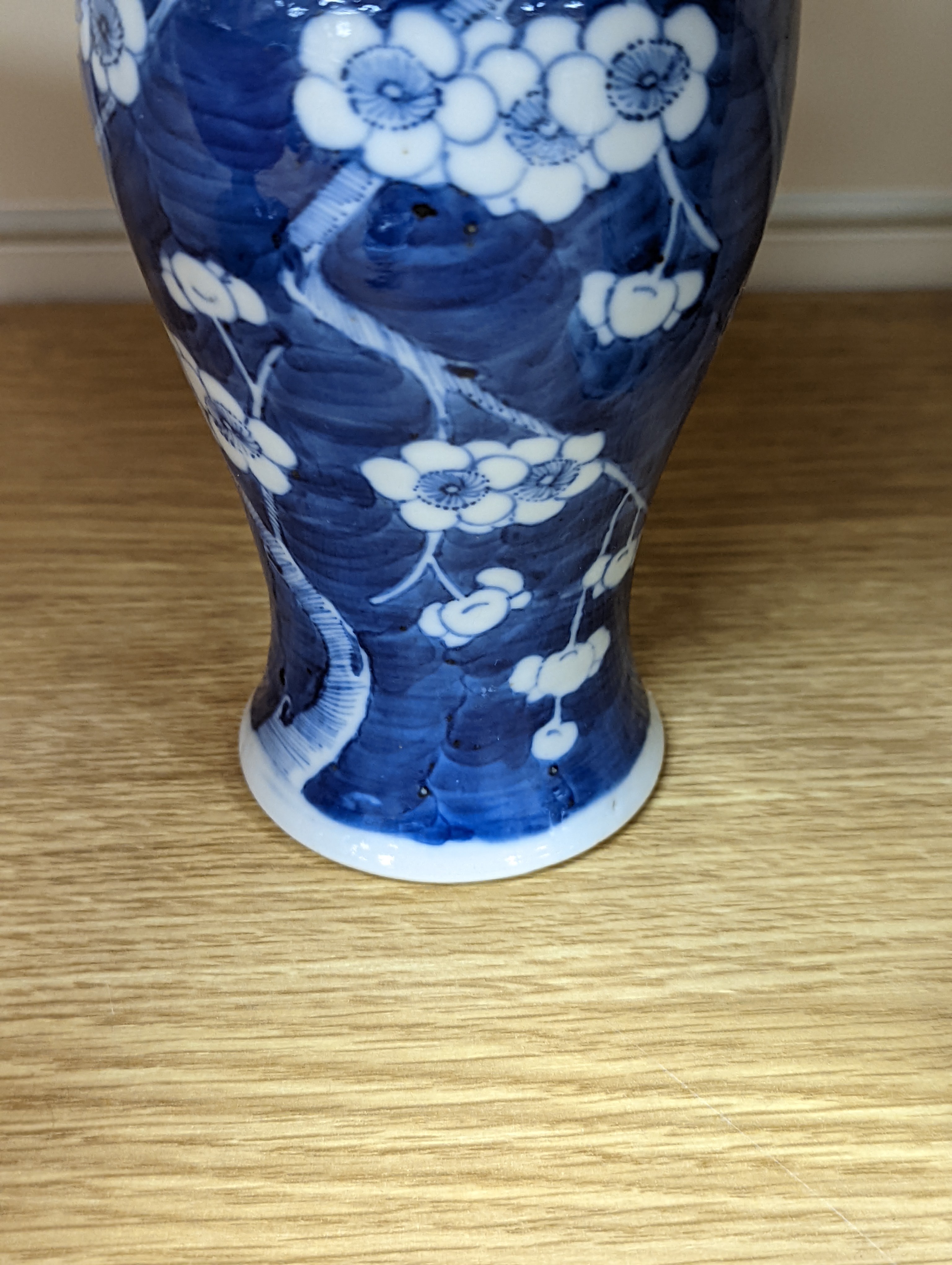 A pair of 19th century Chinese blue and white vases, a prunus vase and cover and a similar jar (4), pair of vases 24 cms high.
